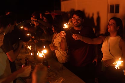 Varias personas sujetan bengalas durante la celebración de la noche de San Juan, este domingo en Barcelona.