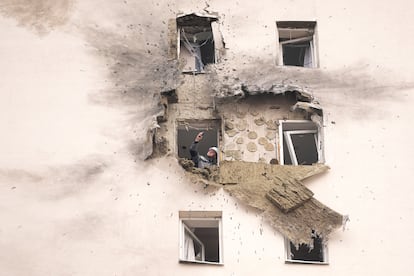 An investigator looks at damage to an apartment building where a downed Ukrainian drone landed in Sapronovo, on the outskirts of Moscow, Tuesday.