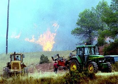 Varios agricultores colaboran con sus tractores en las labores de extinción del incendio.