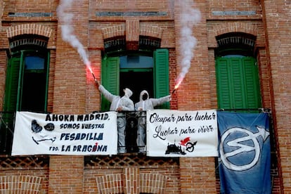 Dos okupas de La Dragona sujetan dos bengalas, tras la inspecci&oacute;n frustrada de ayer. 