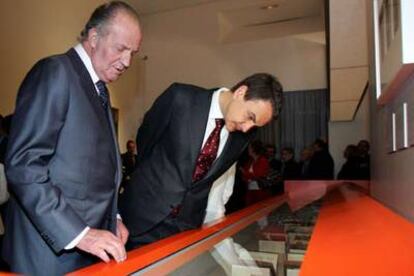 El Rey y el presidente del Gobierno, José Luis Rodríguez Zapatero, observan los libros de la exposición.