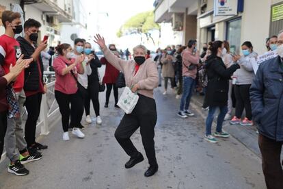 Una mujer baila junto a la administración de lotería de Barbate (Cádiz) que ha vendido el tercer premio.