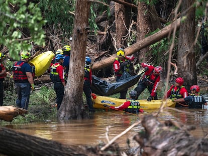 Bomberos de Ciudad Acuña suben un cuerpo a una balsa en el río Guadalupe, durante la emergencia en Texas.