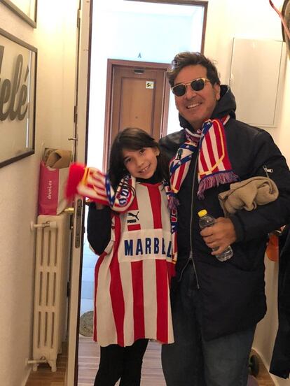 Carlos Yuste y su hija, Isabel, ataviados con bufandas y camisetas del Atltico de Madrid en su domicilio.