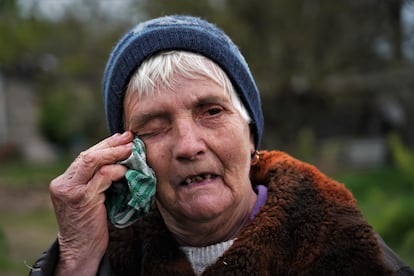 Maria Nikolaevna, de 75 años, se lamenta después de que la casa de su vecino haya sido destruida por un misil ruso.
