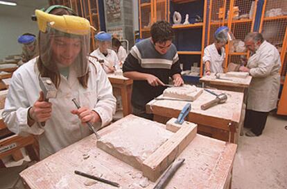 Estudiantes de la Escuela de Artes La Palma de Madrid tallando madera.