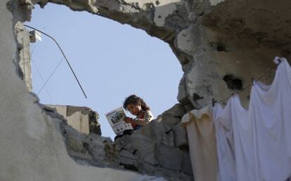 Una niña palestina lee un libro el pasado sábado en el tejado de su casa destruida en la ofensiva de Israel sobre Gaza.