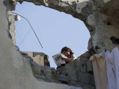 Una ni&ntilde;a palestina lee un libro el pasado s&aacute;bado en el tejado de su casa destruida en la ofensiva de Israel sobre Gaza. 