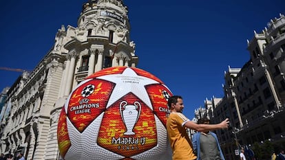 A passerby takes a selfie with a giant replica of the UEFA Champions League ball displayed in Madrid on May 29, 2019 ahead of the final football match between Liverpool and Tottenham Hotspur on June 1. (Photo by GABRIEL BOUYS / AFP)