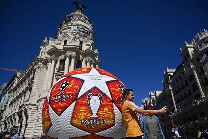 A passerby takes a selfie with a giant replica of the UEFA Champions League ball displayed in Madrid on May 29, 2019 ahead of the final football match between Liverpool and Tottenham Hotspur on June 1. (Photo by GABRIEL BOUYS / AFP)