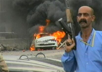 Un hombre esgrime un arma en el lugar del atentado, poco después de la explosión.