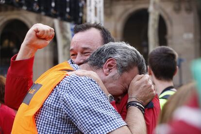 Dos hombres se abrazan y lloran celebrando el resultado de la votación en el Parlament de Cataluña.