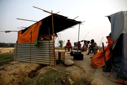 Indian labourers sit near their temporary shelter after working on the construction of a bridge for the new railway in Janakpur, Nepal, June 4, 2017. REUTERS/Navesh Chitrakar  SEARCH "CHITRAKAR RAILWAY" FOR THIS STORY. SEARCH "WIDER IMAGE" FOR ALL STORIES.