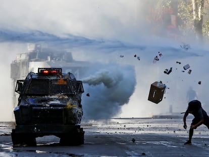 Un manifestante arroja artículos contra un vehículo blindado durante una protesta contra el gobierno de Chile en Santiago, Chile, 30 de diciembre de 2019.