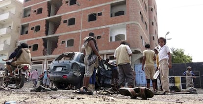 Varias personas inspeccionan el lugar de un atentado suicida, este lunes en Ad&eacute;n. 