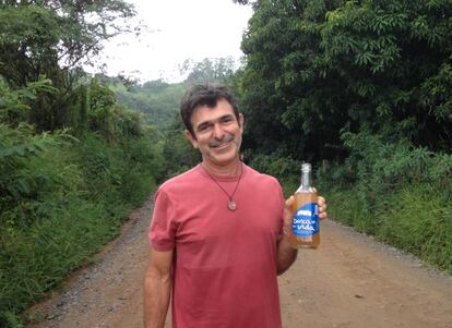 Carlos de Oliveira, Carlão, con una botella de su cachaza.