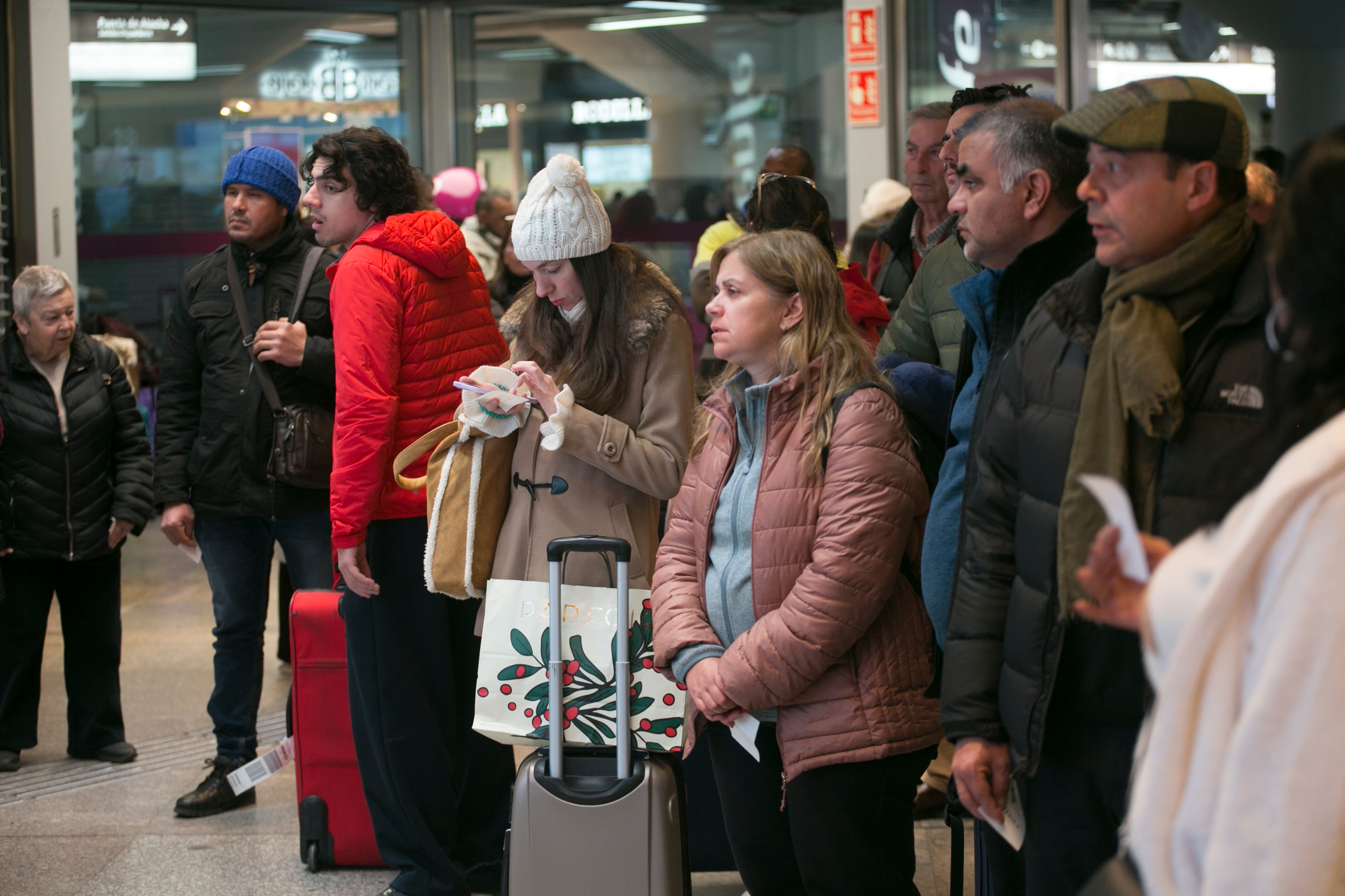 Varios viajeros observan los paneles de trenes en la estación de Atocha, en Madrid, el 19 de enero.
