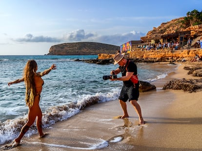 Una modelo posa en Cala Comte, Ibiza. Al fondo, el Chiringuito Cala Escondida, uno de los mejores lugares para disfrutar del atardecer en esta parte de la isla.