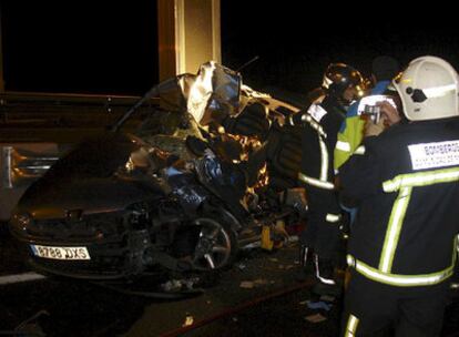 Un bombero graba con su cámara los restos del vehículo accidentado en la AP-6 a la altura de Guadarrama