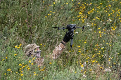 A volunteer soldier holds a drone used to drop explosives at a training area outside kyiv, Ukraine, in 2022. 