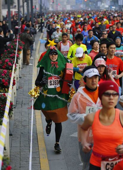 Un hombre disfrazado de árbol de Navidad compite en el tradicional Maratón Internacional de Shanghái, 1 de diciembre de 2013.