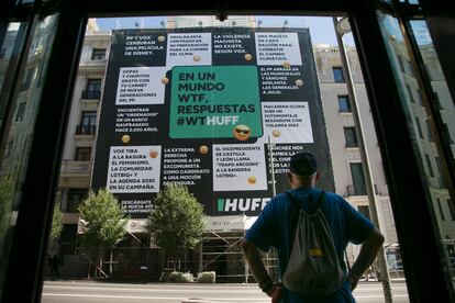 Un transeúnte observa la lona desplegada por El HuffPost en la calle Gran Vía de Madrid, este jueves.