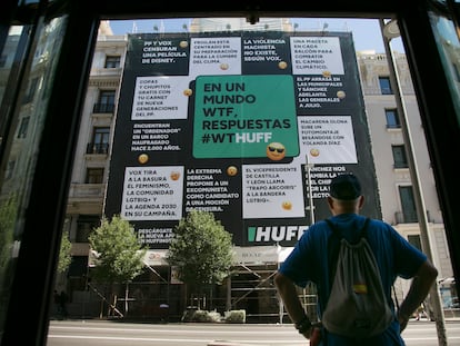 Un transeúnte observa la lona desplegada por El HuffPost en la calle Gran Vía de Madrid, este jueves.