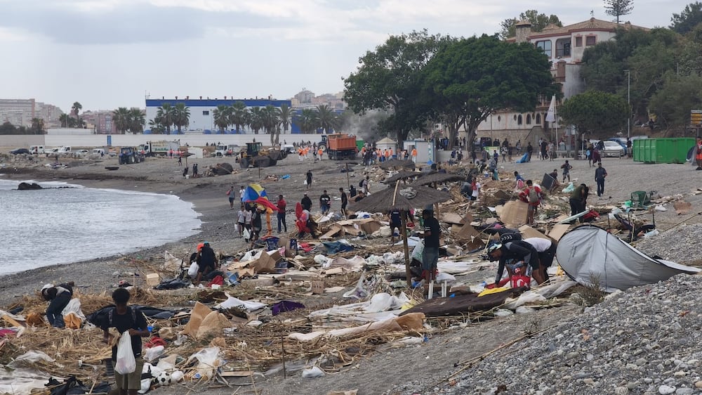 Varias personas recogen sus pertenencias del asentamiento improvisado de la playa del Trampolín, a 20 de agosto de 2026, en Ceuta (España).