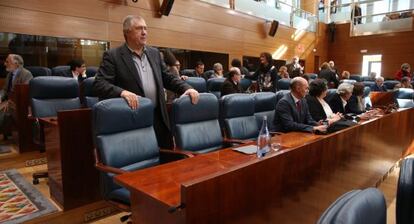 José Quintana, de pie, ante los escaños vacíos de Tomás Gómez y Manu Menéndez hoy en el Pleno de la Asamblea de Madrid.