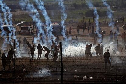 Manifestantes palestinos se protegen de los gases lacrimógenos israelíes.