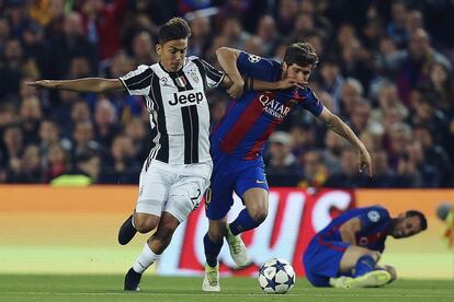 El defensa del Barcelona Sergi Roberto (d) lucha el balón con el argentino Paulo Bruno Dybala, delantero de la Juventus.