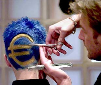Un peluquero da forma al símbolo del euro en el cabello de un joven en Bélgica.