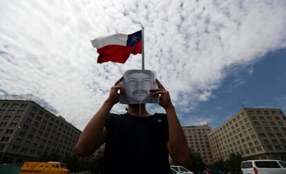 Un manifestante tapa su rostro con una foto del mapuche Camilo Catrillanca durante una protesta en Santiago, el 20 de diciembre.