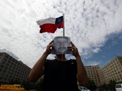 Un manifestante tapa su rostro con una foto del mapuche Camilo Catrillanca durante una protesta en Santiago, el 20 de diciembre.