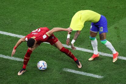 El mediocentro serbio  Sasa Lukic agarra de la camiseta al delantero brasileño  Neymar  durante su primer partido en el Mundial de Catar.  