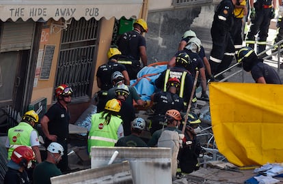 Los bomberos extraen el cuerpo de una víctima en el derrumbe de un edificio en Los Cristianos, en el municipio de Arona, en la isla de Tenerife, Canarias, el 14 de abril de 2016.