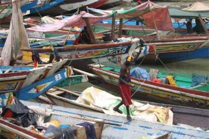 Un pescador salta entre las barcas amarradas en el puerto del barrio de Bandim (Bissau).