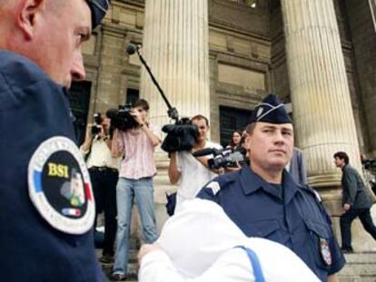 Uno de los acusados ocultó ayer su rostro al entrar al tribunal de Angers.