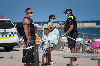 Un agente de la Guardia Urbana cierra los accesos a la playa de Barcelona este sábado.