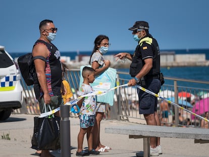Un agente de la Guardia Urbana cierra los accesos a la playa de Barcelona este sábado.