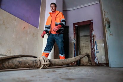 Un trabajador realiza labores de dragado en el hueco de un ascensor averiado por la inundación en Paiporta, afectada por la dana.