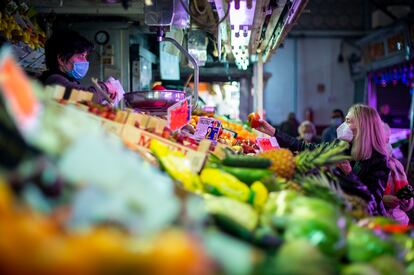 Varias personas con mascarilla en el interior de un mercado.