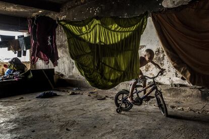 Un habitante del inmueble monta en bicicleta en el edificio okupado del IBGE, en la favela Mangueira, Río de Janeiro, Brasil. En Río existen más de 800 favelas, que van desde las comunidades más recientes o más desfavorecidas, donde las condiciones de vida son las de un suburbio, hasta los barrios en los que todo funciona a la perfección.