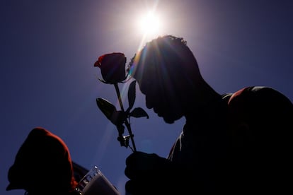 Un hombre lleva una rosa durante la protesta afuera de las instalaciones del INM en Ciudad Juárez, este martes.