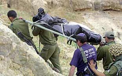 Soldados israelíes transportan ayer el cadáver de uno de los dos adolescentes apedreados y asesinados junto al asentamiento de Tekoa.