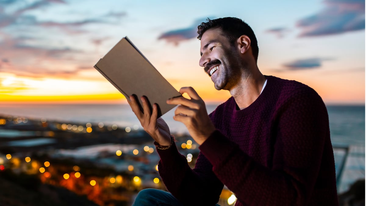 Un hombre leyendo durante el atardecer.