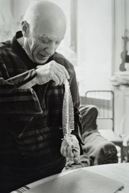 Picasso con una espina de lenguado, antes de realizar un impresión en barro para aplicarlo a una de sus cerámicas.