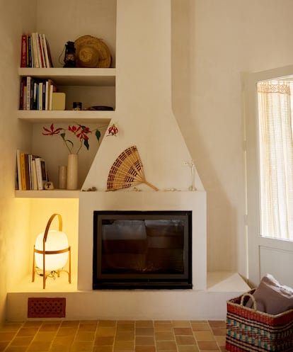Recuerdos de viajes, como el abanico sobre la chimenea, se mezclan con piezas de diseño, como la lámpara de Miguel Milá.
