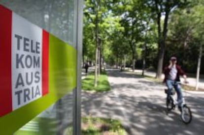 Un ciclista pasa al lado de un cabina telef&oacute;nica de Telekom Austria