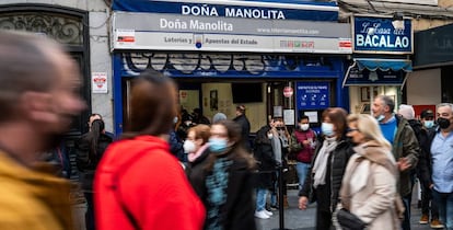 Un grupo de personas pasa frente a Doña Manolita, en Madrid.